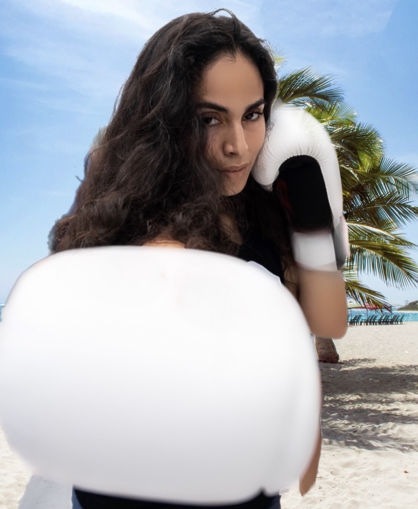 Coach Patty in boxing stance on a Miami beach with white boxing gloves raised